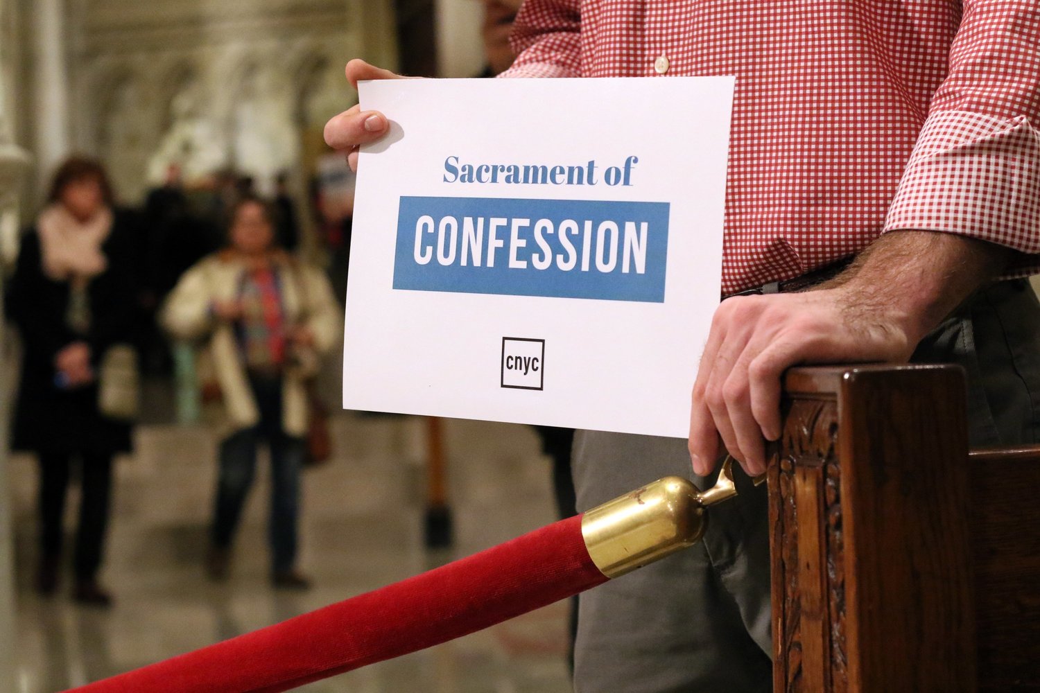 Dustin DiSalvo directs people to reconciliation stations during a Holy Hour for young adults in the Cathedral of St. Patrick in New York City in this 2016 file photo.